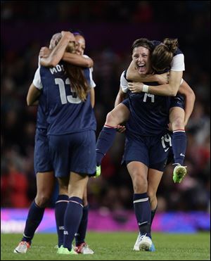 The United States' Abby Wambach, center right, celebrates with teammates including her teammate Kelley O'Hara on her back and scorer of the winning goal Alex Morgan, left with back to camera, after their semifinal win over Canada in their women's soccer match today at the 2012 London Summer Olympics.