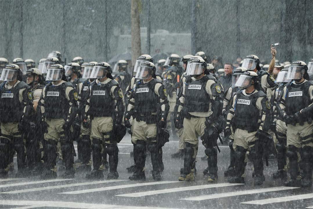 APTOPIX-Republican-Convention-Protests-officers-downpour