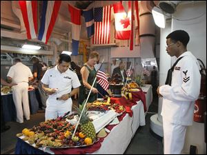 Navy-Week-De-Wert-Michael-Stephens.jpg U.S. Navy Culinary Specialist 2nd Class Michael Stephens, right, watches guests get their food during a reception aboard the U.S. Navy frigate USS De Wert.