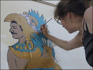 Broadway-murals-Andzaldua.jpg Betty Anzaldua, an Organization of Latino Artists artist, touches up a mural on the building at the corner of Jervis and Broadway. The colorful painting is a collaboration between other art groups, and is one of 16 along Broadway.