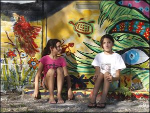 Broadway-murals-Mirando-Nino-Micaela-Serratos.jpg Neighborhood girls Miranda Nino, 9, left, and Micaela Serratos, 11, painted the steps they are sitting on for a mural on the corner of Jervis and Broadway .