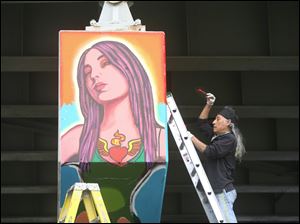 Broadway-murals-Torero-woman-heart.jpg Mario Torero works on the final section of the mural on the I-75 overpass on Broadway and Logan streets.
