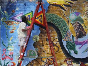 Broadway-murals-Bob-Garcia.jpg Bob Garcia, an Organization of Latino Artists member, touches up a mural on the building at the corner of Jervis and Broadway in Toledo. The colorful painting is a collaboration between other art groups, and is one of 16 along Broadway.