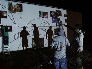 Broadway-murals-Alberto-Marin.jpg Alberto Marin, right, directs volunteers as they trace a mural from a projected image onto a building wall at the corner of Western and Broadway.