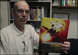 NBRN-author03p.jpg Charles Kelly, with a copy of his book, says he was driven to write it because available texts were outdated and inaccurate. The cover is by an MCCC student.