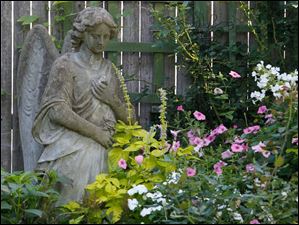 FEA-wiarjanice01p-stone-angel-flowers.jpg An angel looks down on a mix of petunias, impatiens and phlox.