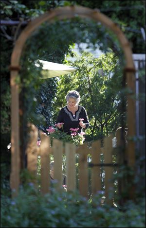 Janice Trudeau is reflected in a cleverly placed mirror, which adds depth to her garden.