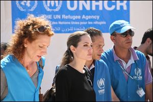 The U.N. refugee agency's special envoy, actress Angelina Jolie, center, arrives to the Zaatari Refugees Camp in Jordan for Syrians who fled the civil war in their country.