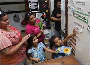 CTY-reading11p.jpg Adriana Borjas, left, stands next to her daughter Reina Conejo, 7, Felicia Guel, center, and her daughter Mya, 6, as they participate in the open house at the Queen of Apostles School in Toledo.
