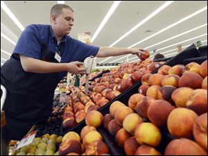 Wholesale-Prices-1.jpg Caleb Tollefson stocks a display of nectarines and peaches at a Hy-Vee grocery store in Sioux Falls, S.D. The Midwest drought has made corn, soybeans, and other grains much more expensive.