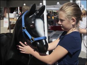Amelia-White-9-of-Waterville.jpg Amelia White, 9, of Waterville, with a plastic horse at the Serenity Farm, Inc. of Northwest Ohio table at the festival. Serenity Farms offers equine assisted learning and a therapeutic riding program at their farm in Luckey, Ohio.