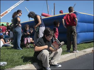 Duncan-Jones-9-of-Perrysburg.jpg Duncan Jones, 9, of Perrysburg, is not distracted by the festival as he finishes a book he is reading. A festival brings out a crowd in downtown Perrysburg.