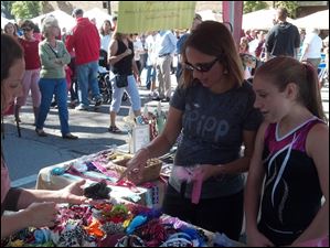 Melissa-Lewicz-center-of-Perrysburg.jpg Melissa Lewicz, center, of Perrysburg, and her daughter Bailey, right, look over the hair bows made by Sara Young, left, at Harrison Rally Day on Saturday, Sept. 15, 2012, in downtown Perrysburg. Ms. Young sells baby accessories and shower gifts through her business Raining Babies.