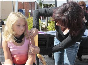 Sophie-Perez-6-of-Perrysburg.jpg Sophie Perez, 6, of Perrysburg, receives a colored hair extension from Jamie Vanderbilt, of Visions Salon and Spa of Perrysburg. A festival brings out a crowd in downtown Perrysburg.