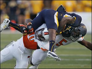 Toledo-wide-receiver-Bernard-Reedy.jpg Toledo wide receiver Bernard Reedy is brought down by Bowling Green defenders Victor Osborne, 34, and Dwayne Woods, 5, during the first quarter of their football game at the Glass Bowl in Toledo.