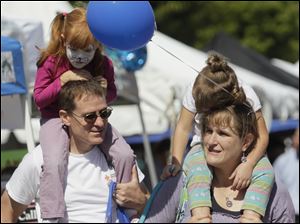 Too-long-at-the-fair-Anabelle-Mora-4-left-and-her-sister-Carina-2.jpg Too long at the fair? Anabelle Mora, 4,left, and her sister Carina, 2, get rides from thier parents Russell, left, and Cordula Mora, of Perrysburg. A festival brings out a crowd in downtown Perrysburg.