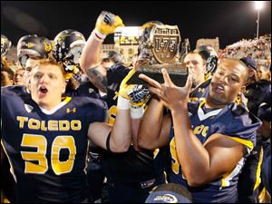 Ben-Pike.jpg Toledo players including Ben Pike, left, and Danny Farr, right, hold trophy after beating Bowling Green.