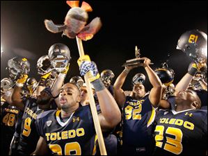 Falcon-stick.jpg Toledo linebacker Robert Bell waves a falcon on a stick as he and teammates celebrate.