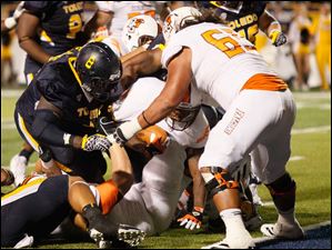 John-Pettigrow.jpg Bowling Green running back John Pettigrow pushes his way toward the goal line as Toledo defensive lineman Elijah Jones, 8, tries to stop him.