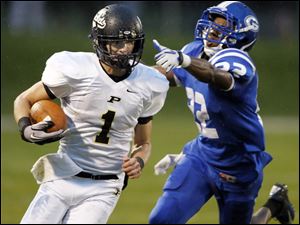 SPT-NLLfootball22p-13.jpg Perrysburg quarterback Steve Slocum (1) runs the ball against Anthony Wayne's Ose Omofoma (22).