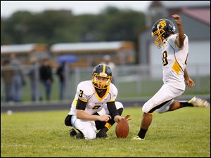 WEBsylv-northviewfball22p-11.jpg Kyle Kremchek, of the Northview Wildcats, holds the ball steady while Alex O'Donnell prepares to kick.