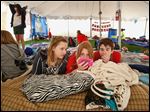  Rachel Phalen, 13, center left, Alexa Borgerson, 13, center, and Luke Kilcorse, 13, take a break and catch up on their television in the District 5 team tent. The 13 teams totaling 130 participants were joined by about 50 volunteers to spend 24 hours together to promote a drug and alcohol-free life. 