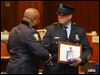 Toledo Police Chief Derrick Diggs, left, presents a Meritorious Service Medal to Officer Mark Johnson during the Toledo Police Department Awards Ceremony at One Government Center today.