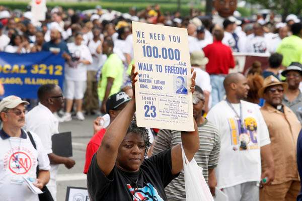 An-original-sign-from-the-MLK-s-Walk-to-Freedom-is-held-high