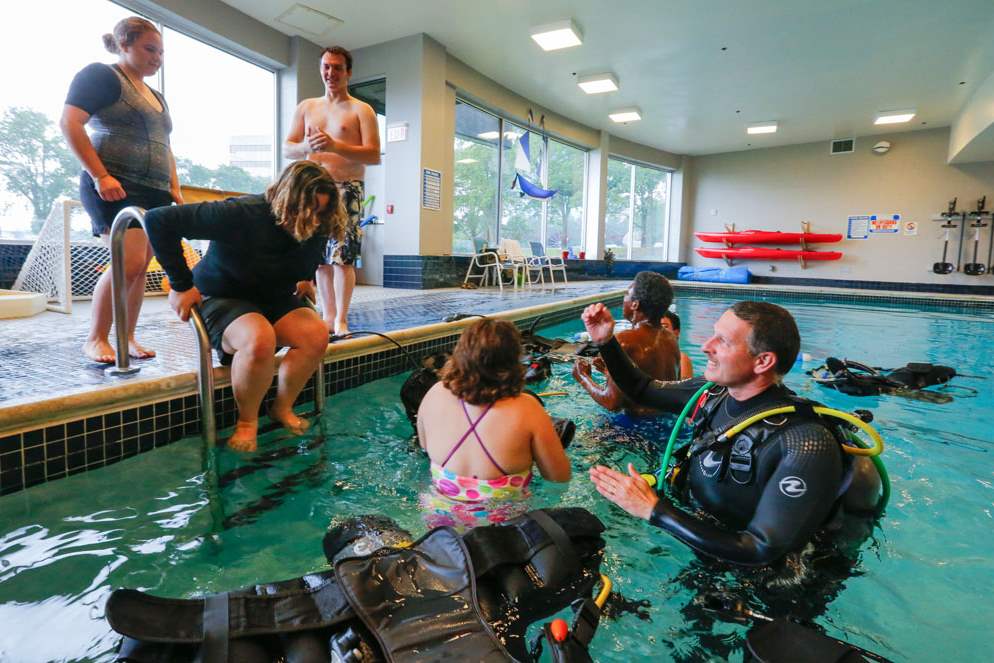 Aqua-Hut-instructor-Tom-Hites-right-helps-students-into-the-water-CTY-scuba26p