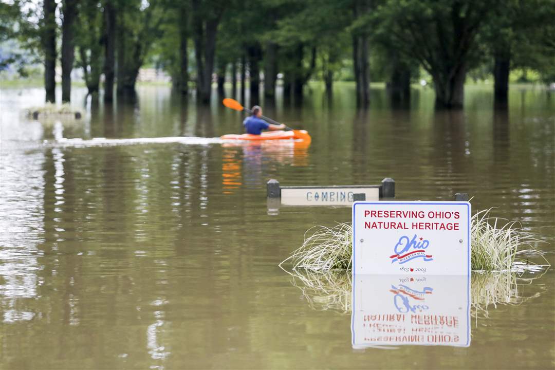 CTY-floodA-man-kayaks-through-the-flooded